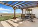 Enjoy outdoor living on this covered patio with table and chairs, overlooking the beautiful landscape at 7172 S Oakleaf St, Bennett, CO 80102