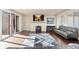 Modern living room featuring a fireplace, large windows, and sleek hardwood floors at 7172 S Oakleaf St, Bennett, CO 80102