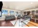 Bright, open-plan living room with large windows and hardwood floors at 7172 S Oakleaf St, Bennett, CO 80102