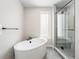 Relaxing bathroom featuring a soaking tub and a glass enclosed shower, complete with gray tile flooring at 2329 Lakeshore Ln # 14, Superior, CO 80027