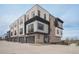 Modern townhome exterior showing a combination of brick, stone, and composite wood accents and attached garages at 2329 Lakeshore Ln # 14, Superior, CO 80027