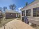 Well-kept backyard with concrete patio, detached brick garage, and white-sided main house at 2330 W 46Th Ave, Denver, CO 80211