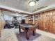 Finished basement features a pool table, wood paneled walls, and a seating area with brick fireplace at 2330 W 46Th Ave, Denver, CO 80211