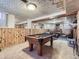 Finished basement featuring a pool table, wood paneled walls, and adjacent living area with fireplace at 2330 W 46Th Ave, Denver, CO 80211