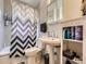 Classic bathroom featuring a pedestal sink, patterned shower curtain, and built-in shelving at 2330 W 46Th Ave, Denver, CO 80211