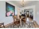 Open dining area with hardwood floors, modern chandelier, and view into the living room at 2330 W 46Th Ave, Denver, CO 80211