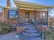 Inviting covered front porch with decorative railing and a view of the brick facade at 2330 W 46Th Ave, Denver, CO 80211