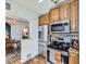 Cozy kitchen features wood cabinets, stainless steel appliances, and a view into the dining area at 2330 W 46Th Ave, Denver, CO 80211
