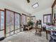 Bright sun room with multiple windows featuring wooden blinds, an overhead skylight, and brick accent wall at 2330 W 46Th Ave, Denver, CO 80211