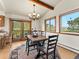 Bright dining room featuring views from windows and sliding doors, wooden beam ceilings, and a chandelier at 24170 Matterhorn Dr, Indian Hills, CO 80454