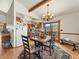 Open dining room with beam ceilings, a chandelier, and access to the deck for outdoor dining at 24170 Matterhorn Dr, Indian Hills, CO 80454