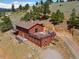 Beautiful home exterior with a large deck, overlooking lush greenery and mountain views at 24170 Matterhorn Dr, Indian Hills, CO 80454