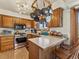 Functional kitchen with wood cabinetry, stainless steel appliances, and pot rack at 24170 Matterhorn Dr, Indian Hills, CO 80454