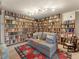 Cozy sitting area with comfortable couch nestled in a room with floor-to-ceiling bookshelves at 24170 Matterhorn Dr, Indian Hills, CO 80454