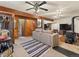 Cozy living room with wood paneling, beamed ceilings, and a wood-burning stove at 24170 Matterhorn Dr, Indian Hills, CO 80454