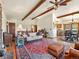 Spacious living room with beam ceilings flowing into dining and kitchen, offering a mountain view at 24170 Matterhorn Dr, Indian Hills, CO 80454