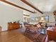Comfortable living room with beamed ceilings, natural light, and mountain views through large windows at 24170 Matterhorn Dr, Indian Hills, CO 80454