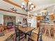 Open living space connecting the dining area, kitchen, and living room with beam ceilings at 24170 Matterhorn Dr, Indian Hills, CO 80454