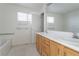 Well-lit bathroom boasting dual sinks, ample counter space, and wood cabinets at 4428 S Kalispell Cir, Aurora, CO 80015