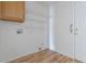 Laundry area featuring wooden cabinet, wire shelving, laminate flooring, and in-wall connections at 4428 S Kalispell Cir, Aurora, CO 80015