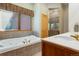 Well-lit bathroom featuring a bathtub, shower, and a sink with a window view, combining functionality and style at 189 Ginger Quill Ln, Breckenridge, CO 80424