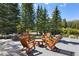 Outdoor deck with wooded views, Adirondack chairs, a table, and an outdoor grill at 189 Ginger Quill Ln, Breckenridge, CO 80424