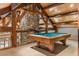 Spacious game room featuring exposed beams, a stone pillar, and a billiard table perfect for entertainment at 189 Ginger Quill Ln, Breckenridge, CO 80424
