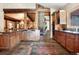 Open kitchen and dining area with stone fireplace, wood beams, stainless steel appliances, and tile flooring at 189 Ginger Quill Ln, Breckenridge, CO 80424
