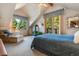 Inviting primary bedroom with a cozy seating area, fireplace, and a private balcony overlooking lush greenery at 189 Ginger Quill Ln, Breckenridge, CO 80424