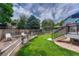 Landscaped backyard features grass, a rock border, sitting area, wooden fence, and a deck with stairs at 21789 Farmingdale Way, Parker, CO 80138