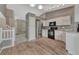 Bright kitchen with stainless steel appliances, light wood floors, and an adjacent living area at 21789 Farmingdale Way, Parker, CO 80138