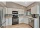 Well-lit kitchen featuring white cabinets, a black range oven, and stainless steel appliances at 21789 Farmingdale Way, Parker, CO 80138