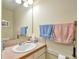 Compact bathroom featuring a sink, mirror, tiled countertop, and towel racks at 18852 E Progress Ave, Centennial, CO 80015
