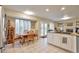 Eat-in kitchen area with views of fireplace, a double sink, white cabinets, and natural light from shuttered windows at 18852 E Progress Ave, Centennial, CO 80015