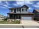 Two-story home with stone accents, gray siding, covered porch, and well-maintained landscaping at 13903 Hillsboro Dr, Parker, CO 80134