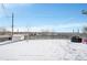 Spacious fenced backyard offering ample space and a storage shed, all covered in fresh snow at 9040 Yucca Way, Thornton, CO 80229
