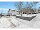 View of the driveway and gated entrance showcasing the property's exterior, with snowy landscape at 9040 Yucca Way, Thornton, CO 80229