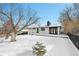Snowy front yard with mid-century modern home at 9040 Yucca Way, Thornton, CO 80229