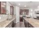 Modern kitchen featuring granite countertops, stainless steel appliances, and dark wood cabinetry at 24043 E Florida Ave, Aurora, CO 80018