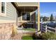 Cozy covered front porch with a porch swing, brick accents, and manicured landscaping, perfect for relaxing outdoors at 24043 E Florida Ave, Aurora, CO 80018