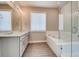 Bright bathroom featuring a large soaking tub and a glass enclosed shower at 274 Marlowe Dr, Erie, CO 80516