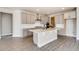 Stylish kitchen featuring gray cabinets, a white island, stainless steel range hood, and wood-look floors at 274 Marlowe Dr, Erie, CO 80516
