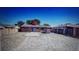 Spacious backyard with dry grass, trees, and brick home with a blue door at 1977 S Yates S St, Denver, CO 80219