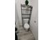 Compact bathroom featuring a toilet with shelving and neutral grey walls at 1977 S Yates S St, Denver, CO 80219