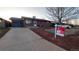 Charming brick home featuring a well-maintained lawn and professional real estate signage at 1977 S Yates S St, Denver, CO 80219