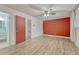 Spacious bedroom with wood-look flooring, ceiling fan, and red accent wall at 544 S Xenon Ct, Lakewood, CO 80228