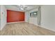 Open bedroom featuring laminate flooring, ceiling fan, an accent wall, and window at 544 S Xenon Ct, Lakewood, CO 80228