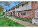 Brick townhouse featuring a tidy lawn, mature trees, and pedestrian walkway at 544 S Xenon Ct, Lakewood, CO 80228