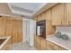 Kitchen with light wood cabinets, island cooktop and stainless steel appliances at 544 S Xenon Ct, Lakewood, CO 80228