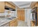 Functional kitchen featuring wood cabinets, modern appliances, and a skylight for natural light at 544 S Xenon Ct, Lakewood, CO 80228